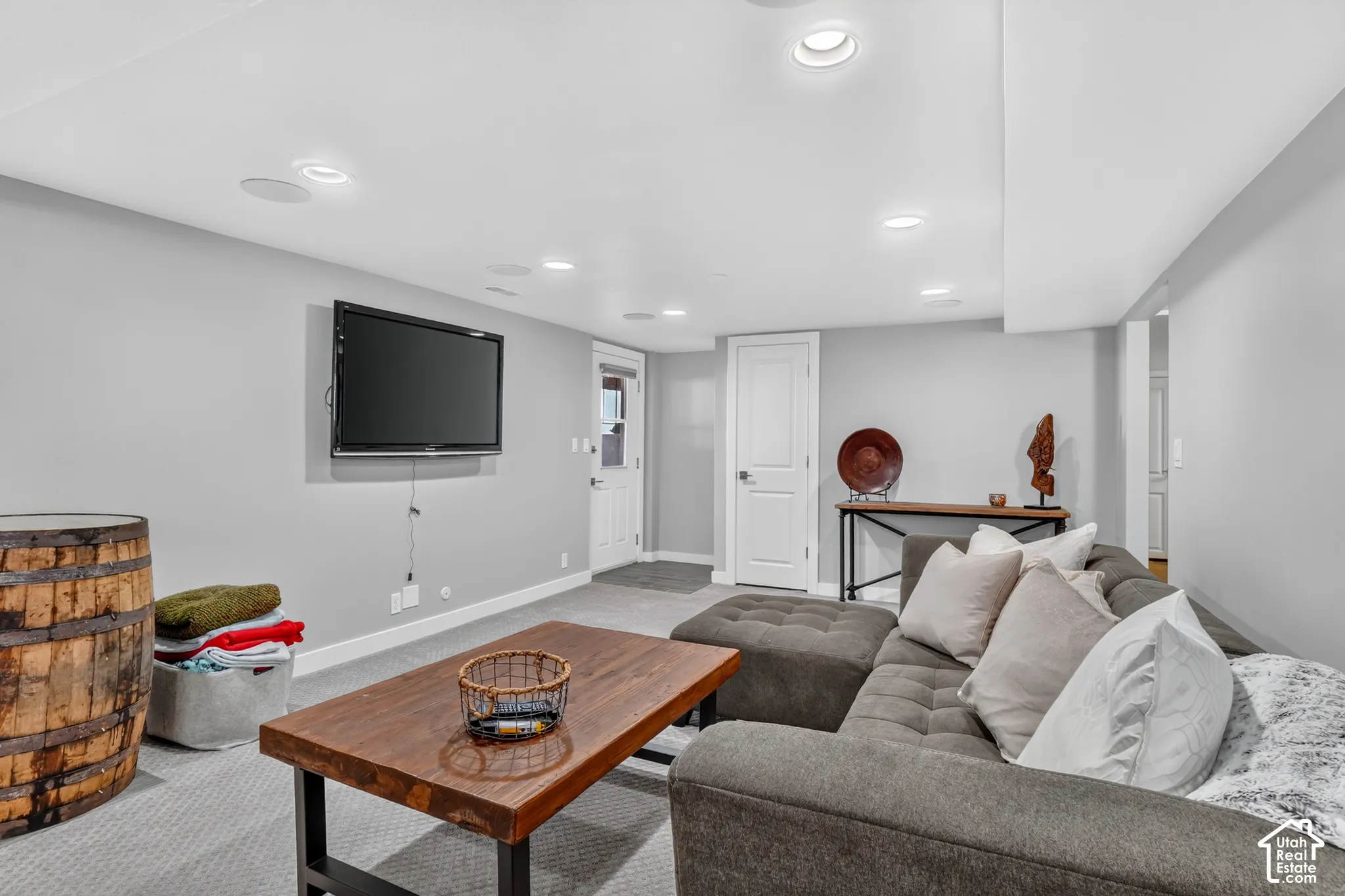 Recessed lighting, wall-mounted television, carpet flooring, console table, white doors