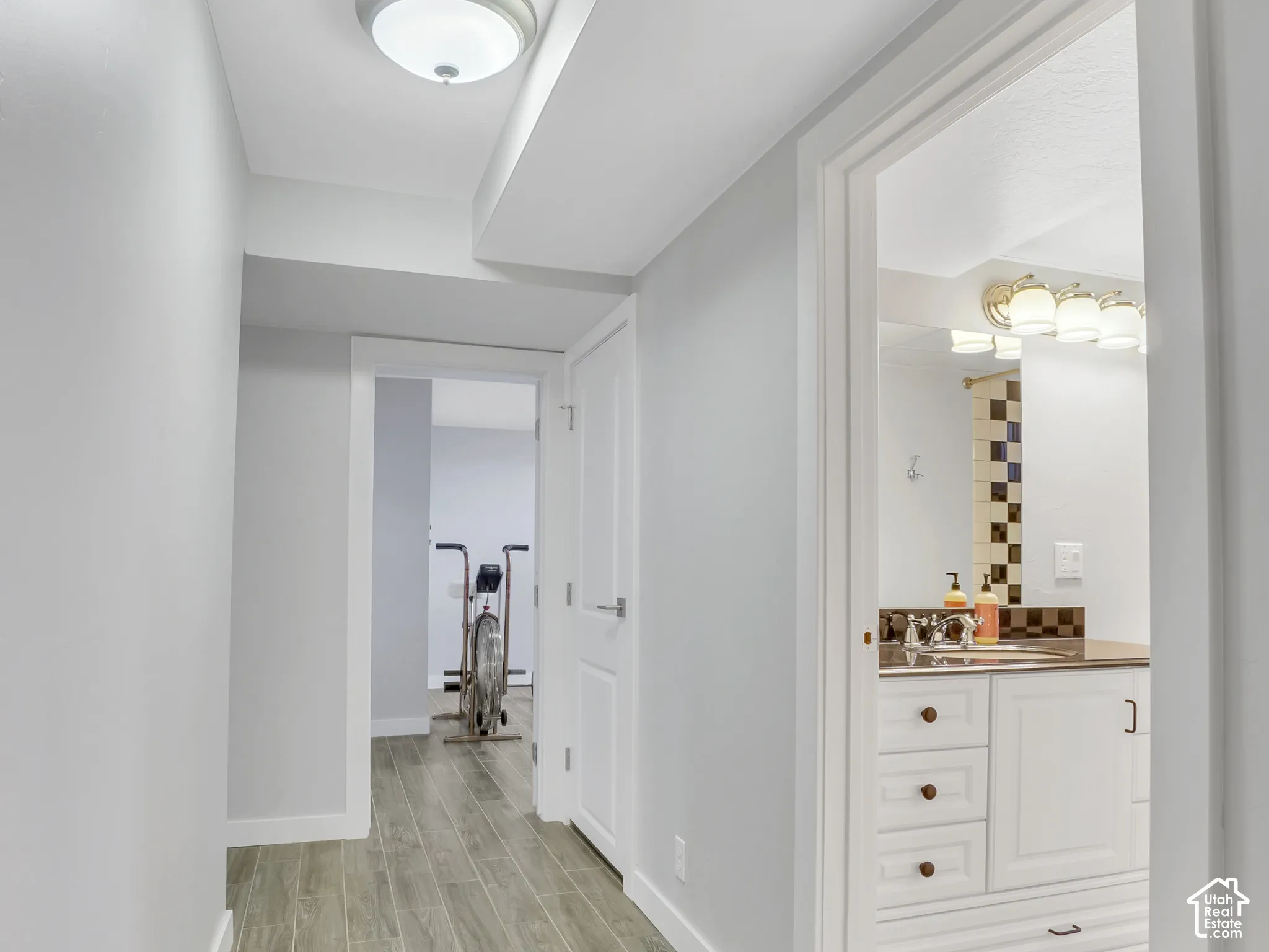 Hallway with wood-finish tile flooring and recessed lighting
