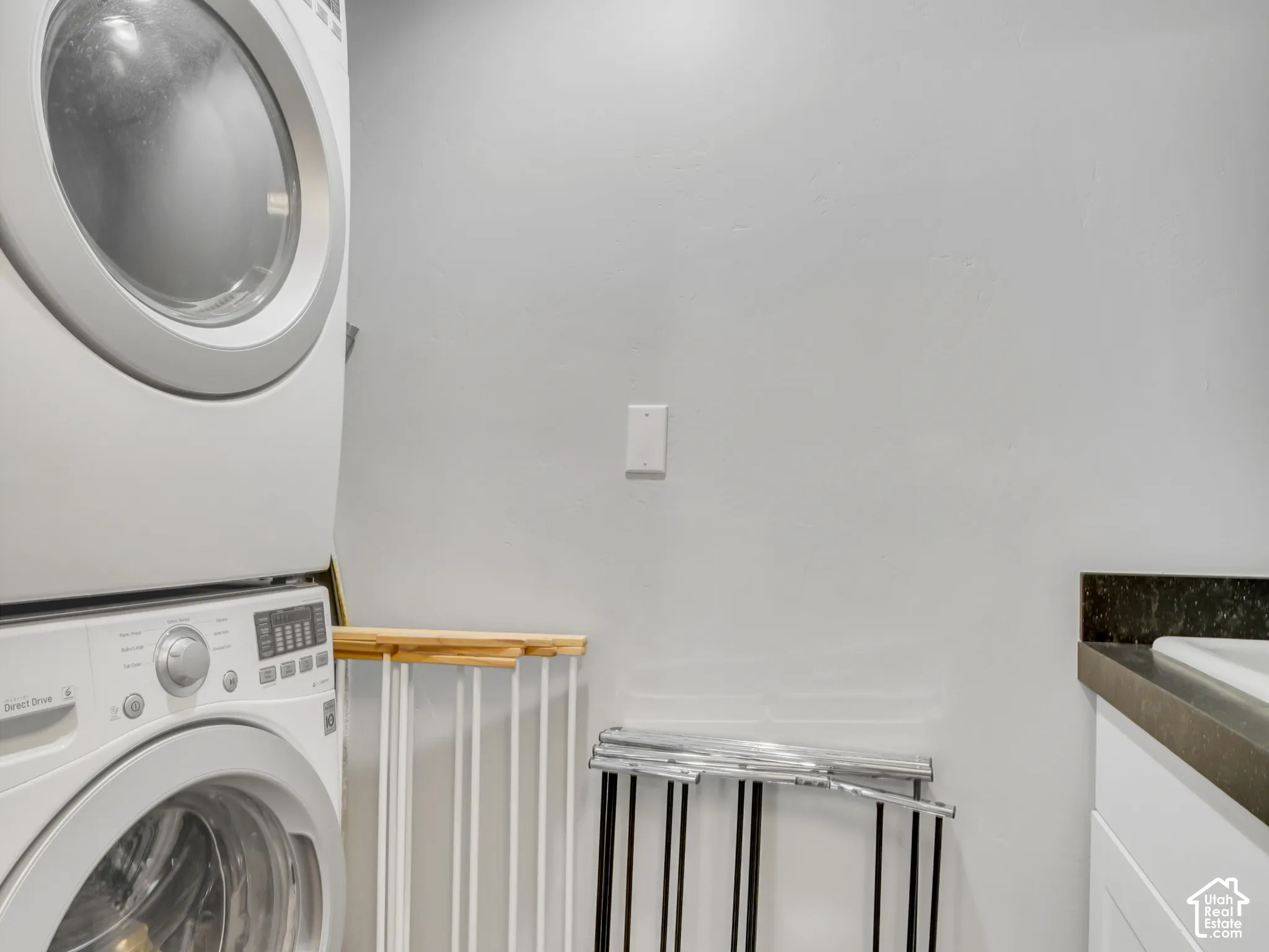 Recessed ceiling light, white painted walls, white cabinetry with silver hardware, dark countertop, and under-mount sink