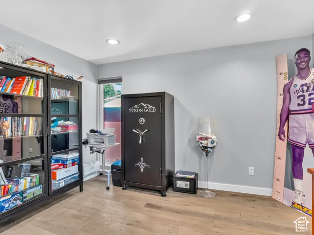 Recessed lighting illuminates the space, featuring wood-finish flooring