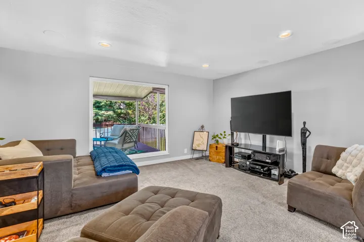 Recessed ceiling lighting, light gray wall paint, gray carpet flooring, large window, and built-in speaker