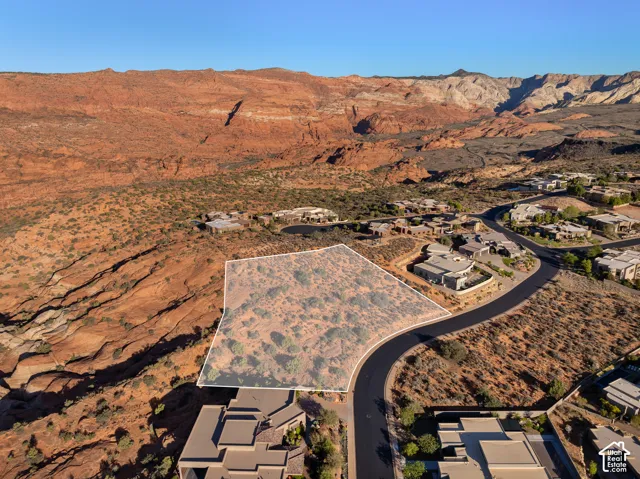 Expansive land parcel featuring natural desert flora, bordering a paved roadway