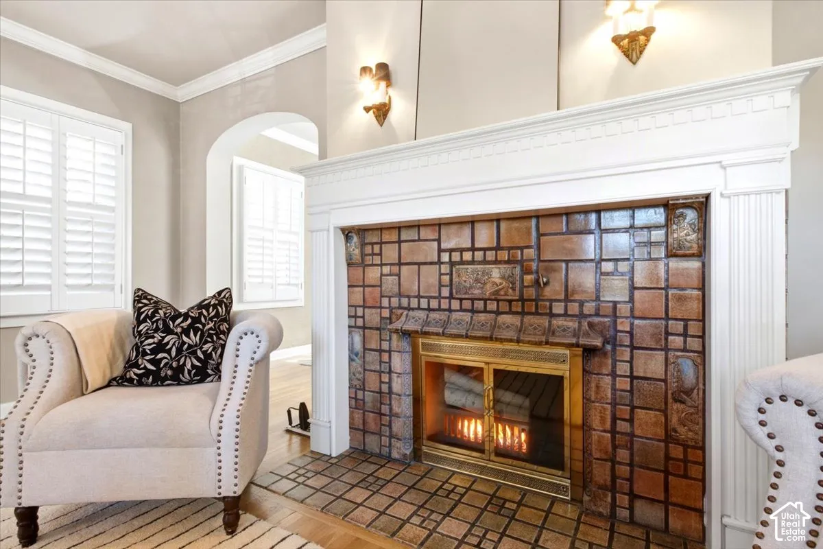 Fireplace featuring a terra cotta decorative tile surround and and brass fire screen