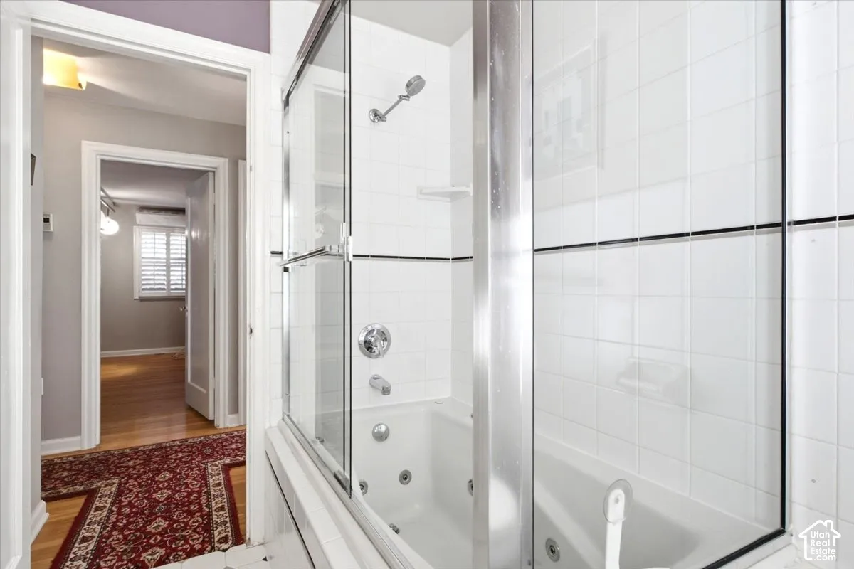 Bathtub with integrated jets and glass shower enclosure
