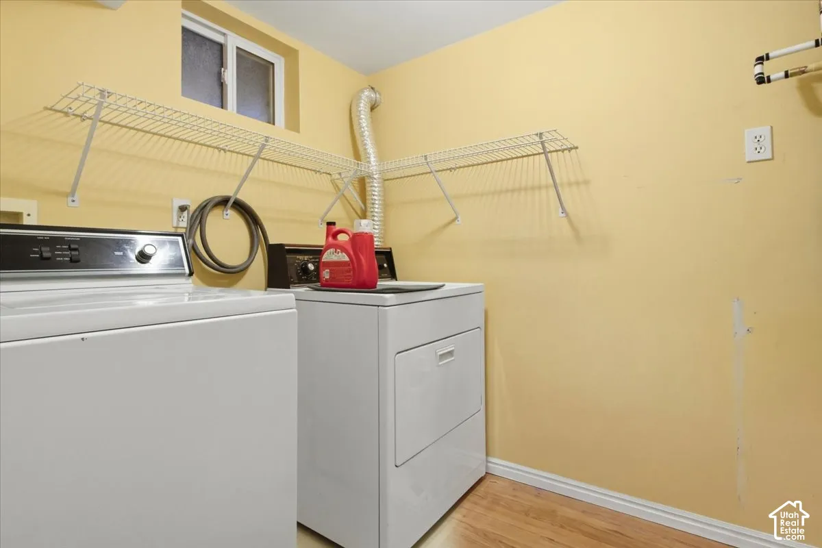 Laundry area featuring a window, wire shelving, and wood-finish flooring