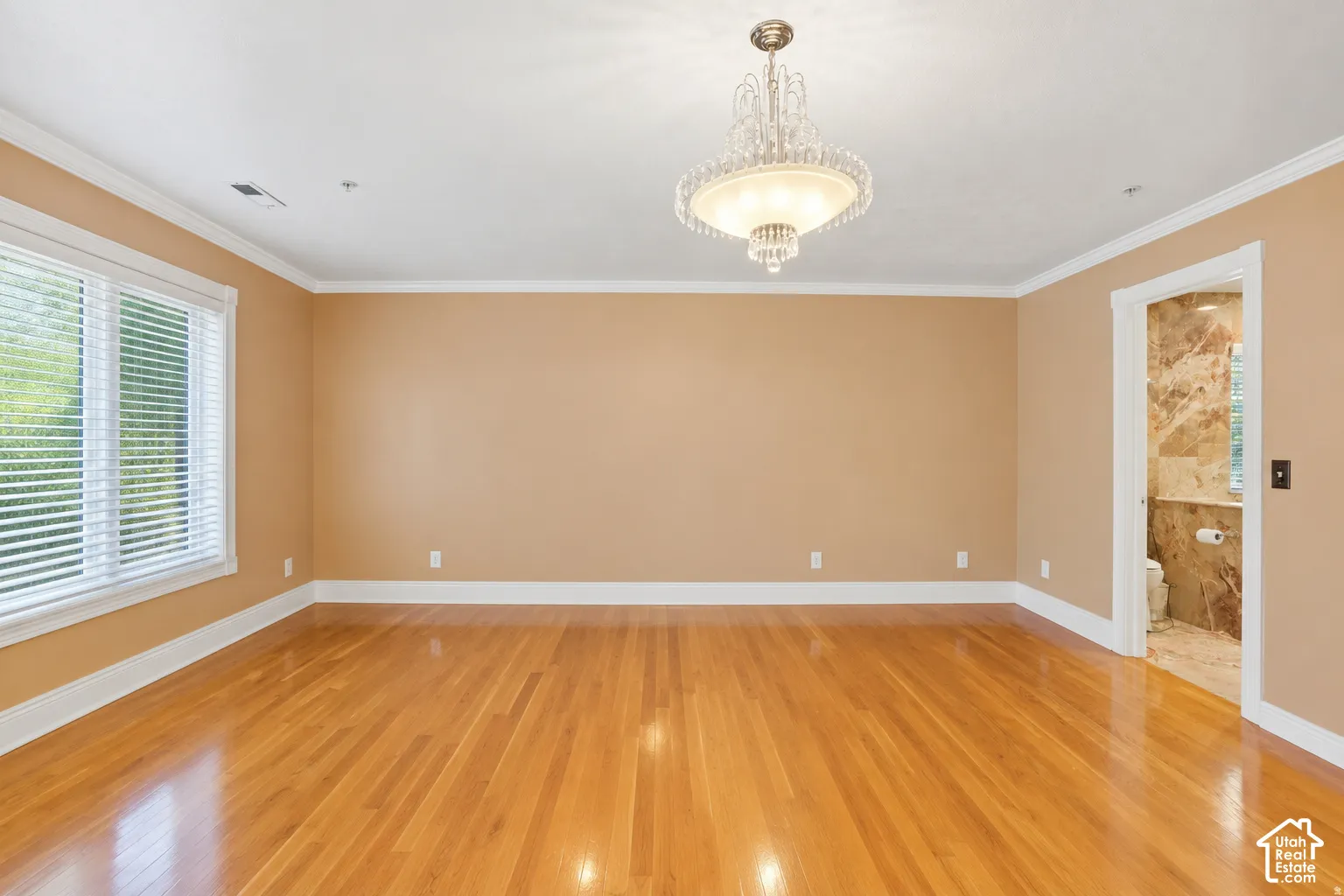 Hardwood-finish flooring, crown molding, and a crystal chandelier