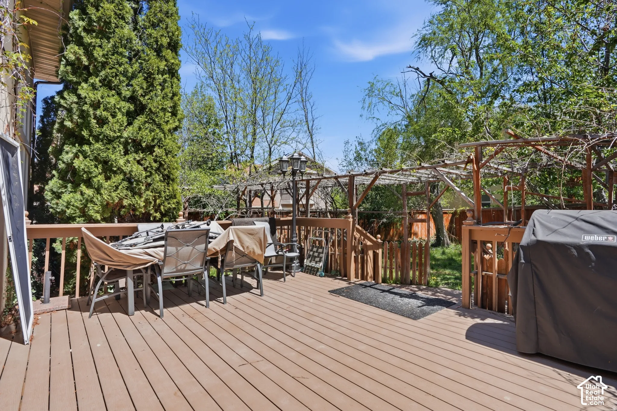 Wood-finish deck with a built-in wooden pergola and privacy fencing