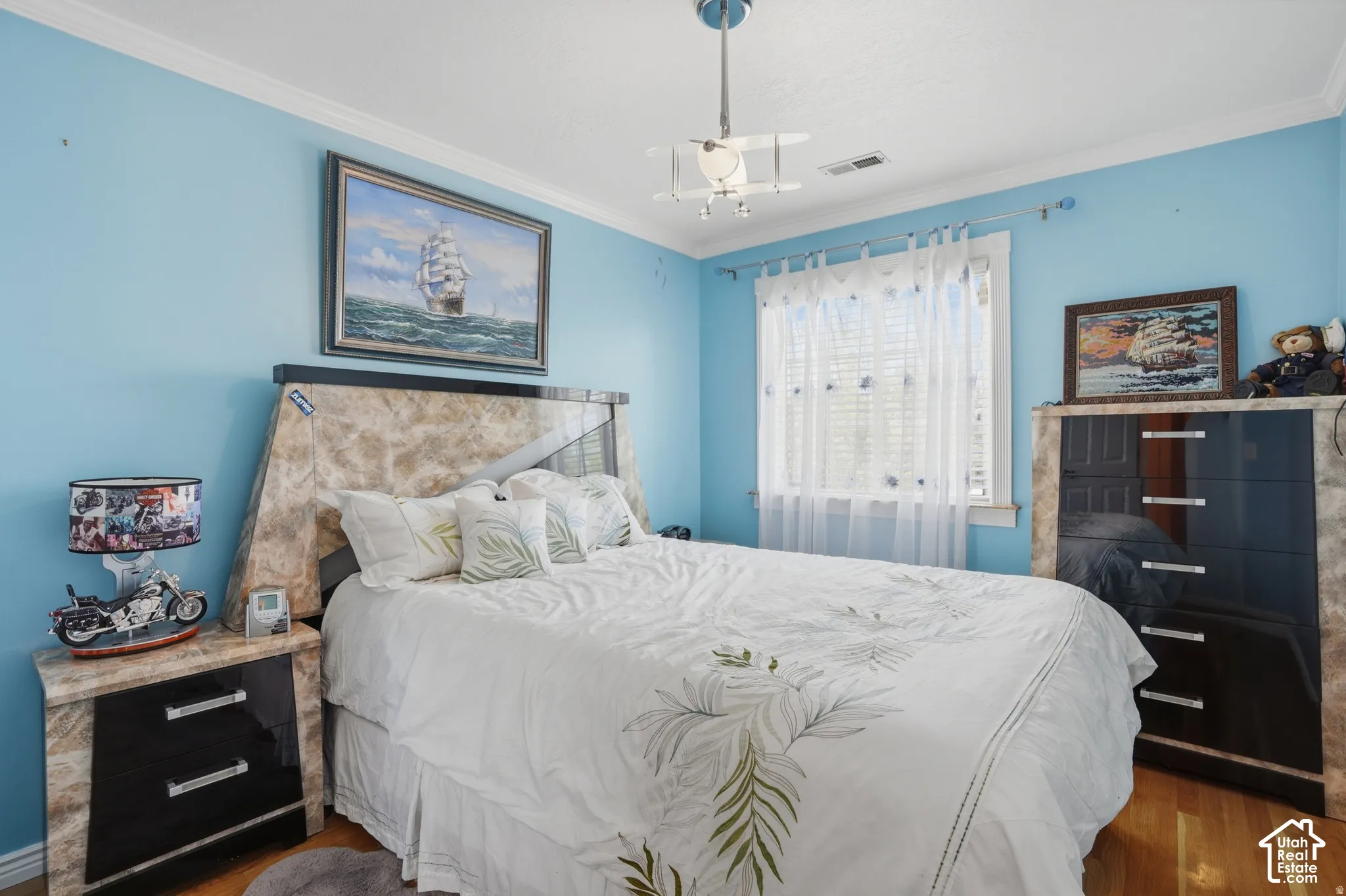 Hardwood flooring, crown molding, white window trim, overhead light fixture, and a window with blinds
