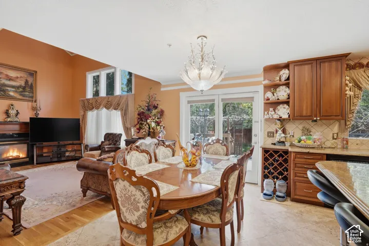 Kitchenette with wood-finish cabinetry, built-in wine storage, and a tiled backsplash