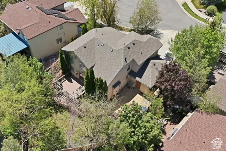Multi-level residence featuring a pitched roof, exterior siding, and mature landscaping