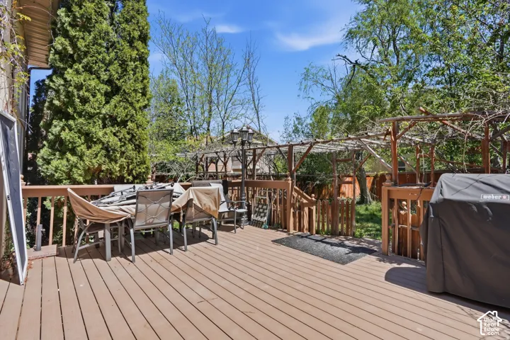 Wood-finish deck with a built-in wooden pergola and privacy fencing