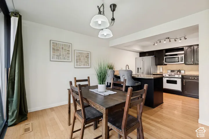 Hardwood-style flooring throughout, with a dining area featuring a pendant light fixture