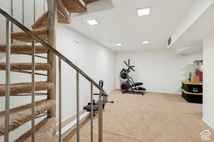 Spiral staircase with carpeted treads and metal railing