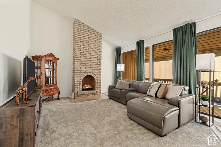 Brick fireplace with hearth, vaulted ceiling, and full-height windows