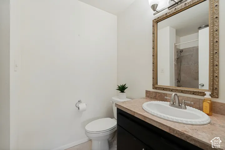 Bathroom featuring a dark wood-finish vanity, an ornate framed mirror, and an oval white sink with a brushed nickel faucet