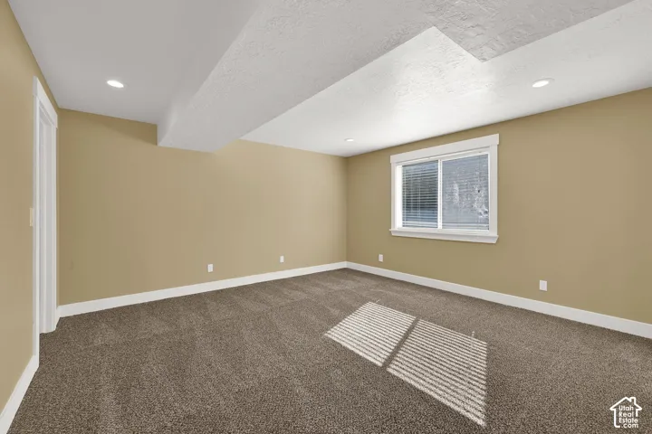 Neutral wall tones, carpeted flooring, recessed ceiling lighting, and a single-pane sliding window with white trim