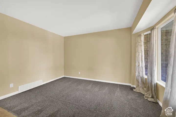 Interior room featuring neutral wall paint, wall-to-wall carpeting, and a multi-panel bay window