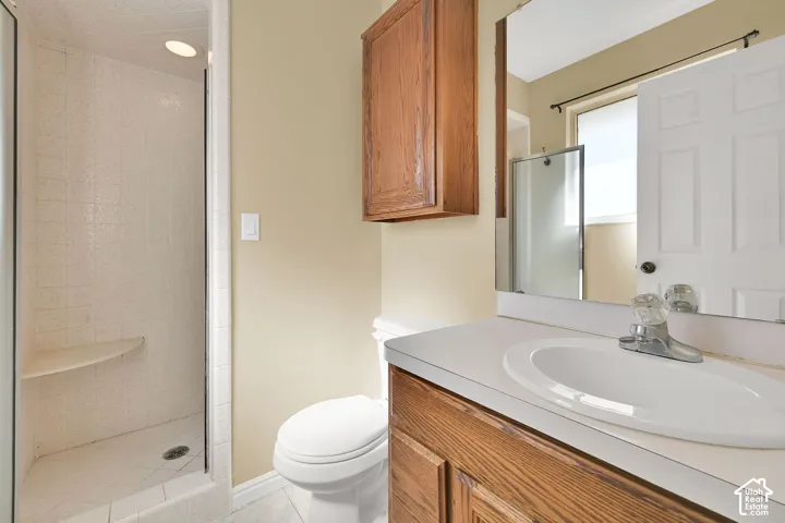 Bathroom featuring a glass-enclosed shower with a built-in corner seat, wood-finish cabinetry, solid-surface vanity countertop with an integrated basin, and a wall-mounted medicine cabinet