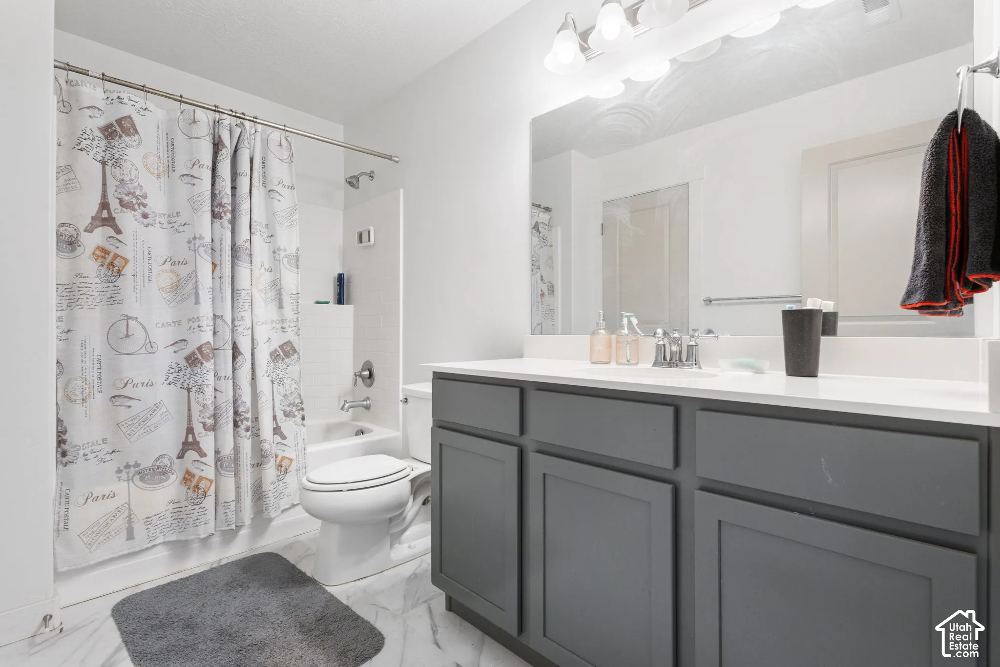 Full bathroom with a tub/shower combination, a vanity with a white countertop, and a large mirror