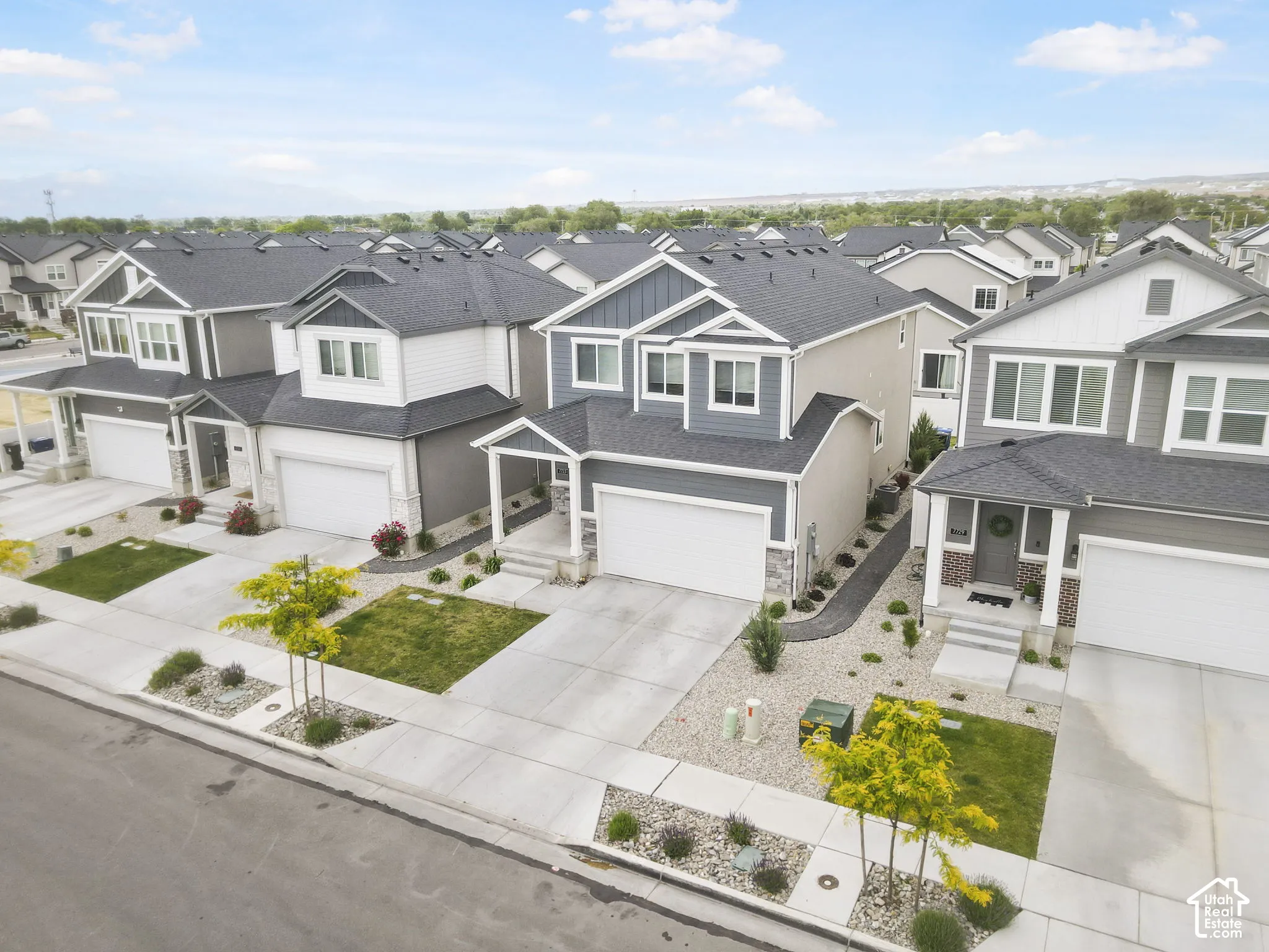 Modern residential architecture with varied siding materials, attached garages, and mature landscaping