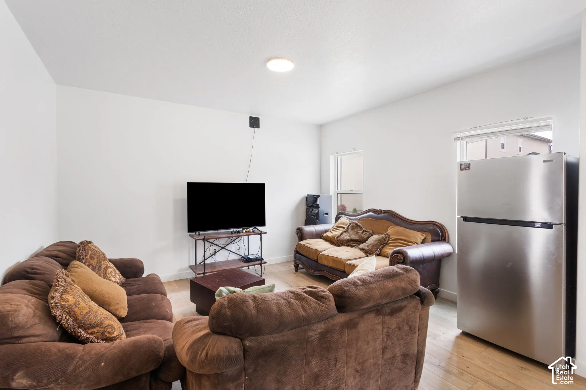 Recessed ceiling lighting, light wood-finish flooring, and white painted walls