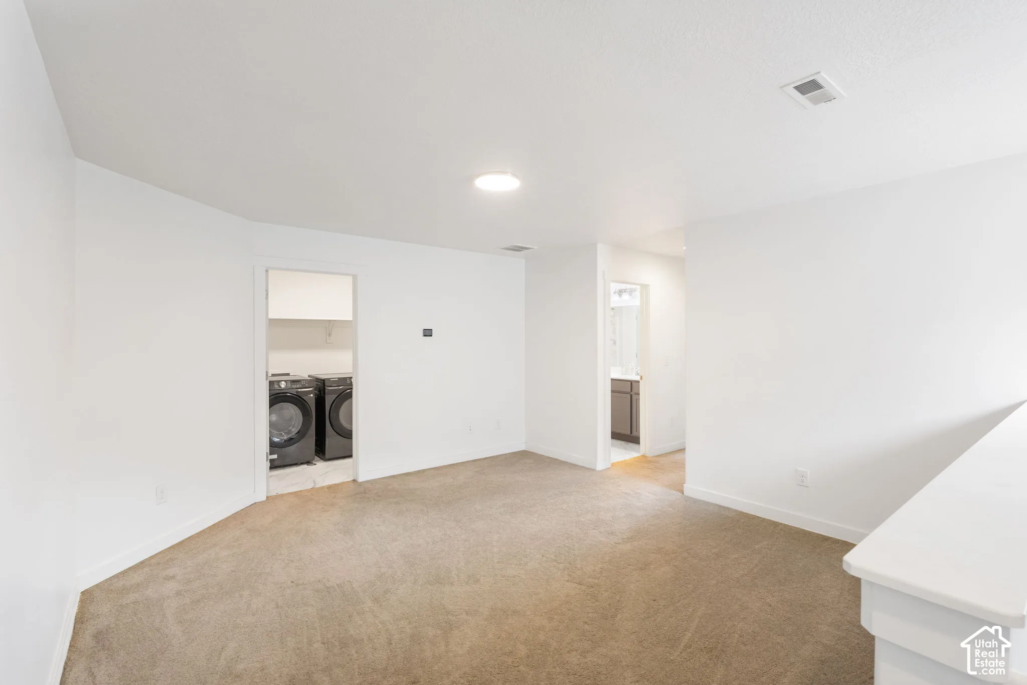 White walls with recessed lighting and neutral carpet