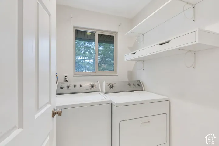 White paneled door with brushed nickel hardware, natural light window, and white wall-mounted shelving