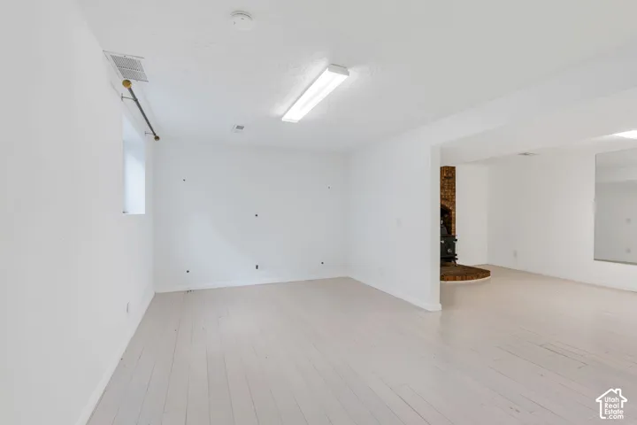 Light wood-finish flooring, white walls, and a recessed window