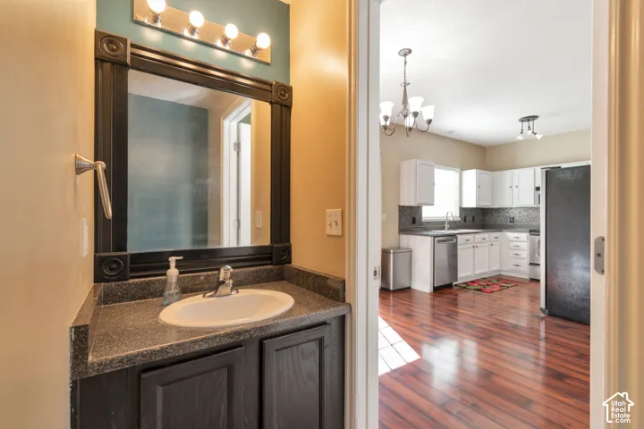 Vanity with integrated sink, framed mirror, and overhead lighting
