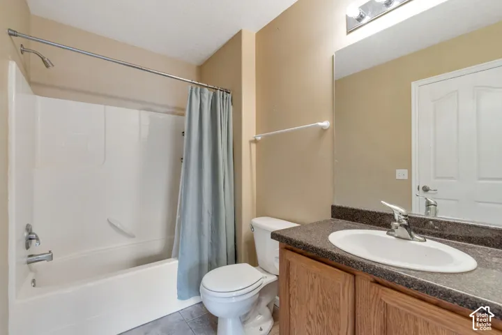 Bathroom featuring a combined shower and tub, wood-finish vanity, and integrated sink