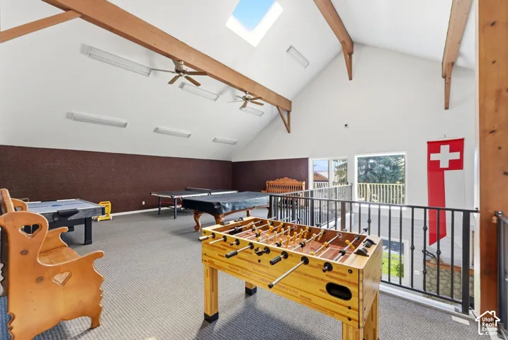 Vaulted ceiling with exposed wood beams, skylight, recessed lighting, and ceiling fans