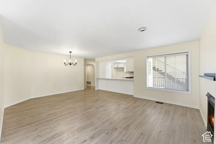 Spacious living area featuring wood-finish flooring, a fireplace, and a large window