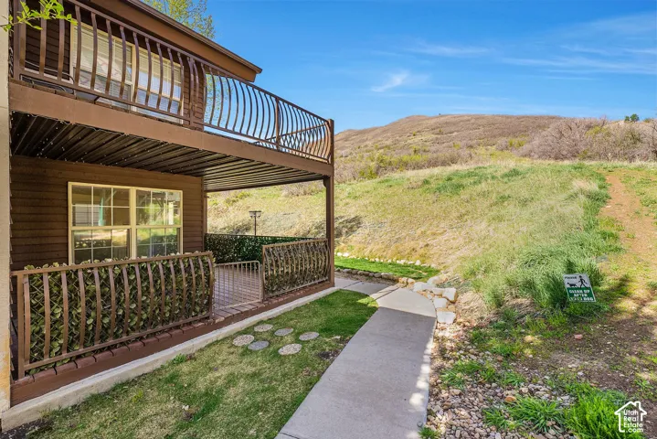 Two-story exterior with a ground-level patio and upper-level balcony, both featuring decorative metal railings