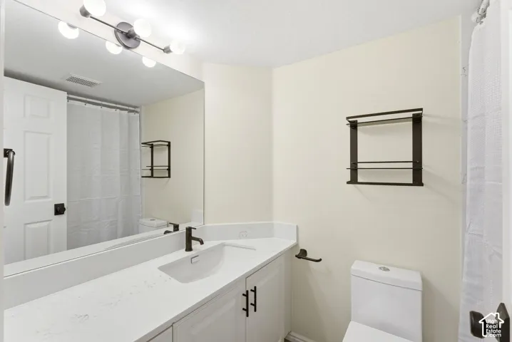 Vanity with integrated sink, white cabinetry, and dark bronze hardware