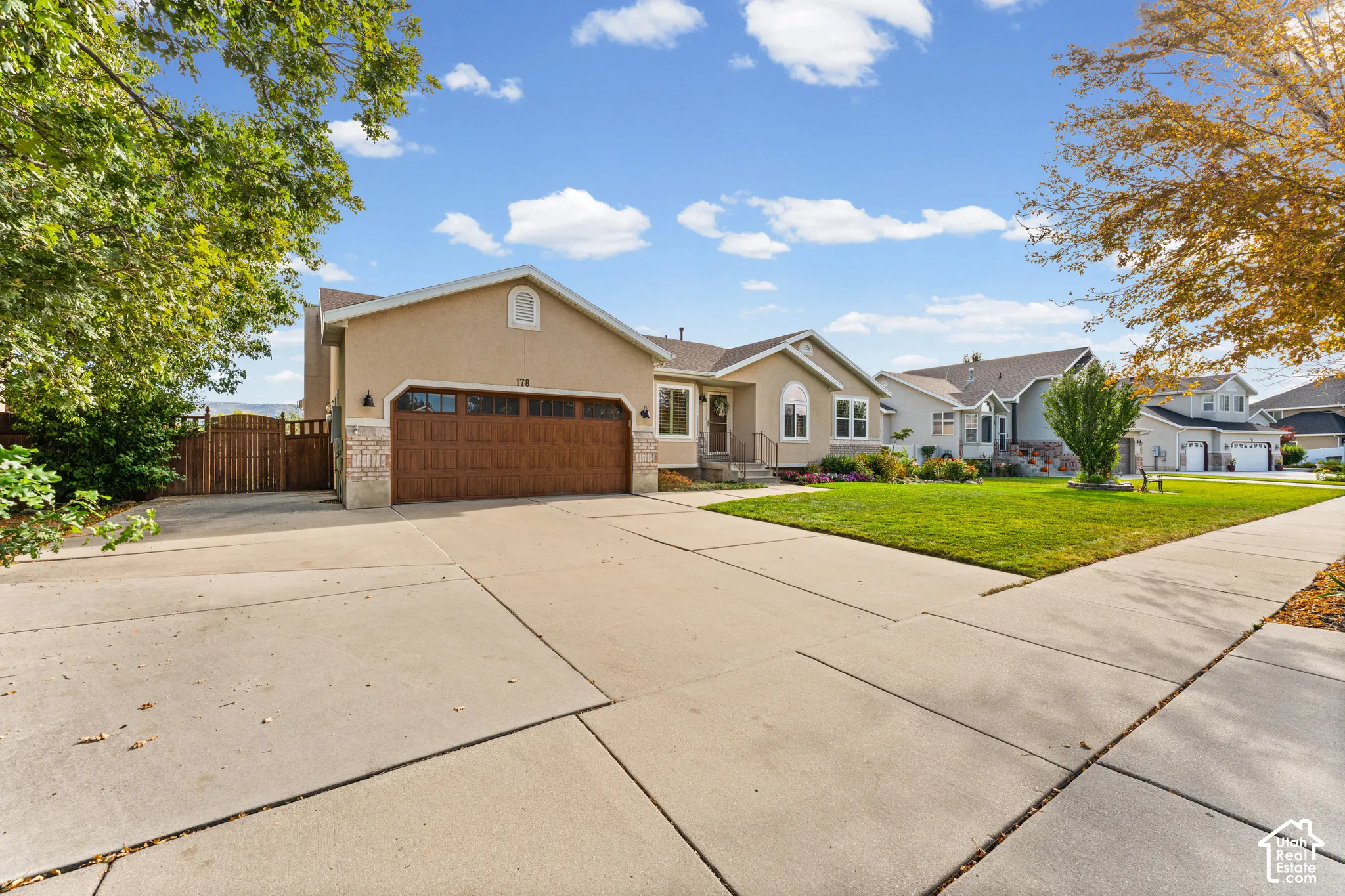 Stucco exterior with stone accents and a wood-finish garage door