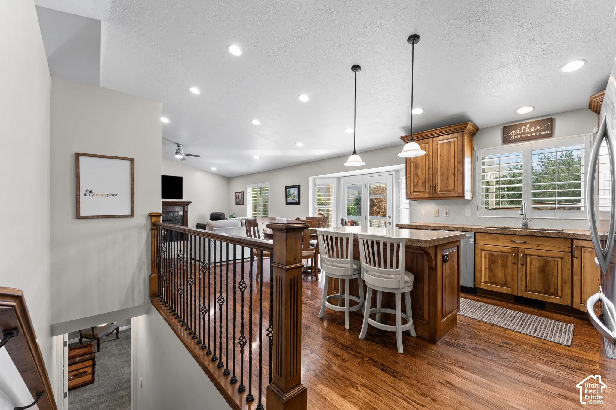 Open-concept living space featuring wood-finish flooring, recessed lighting, and a kitchen island with pendant lighting