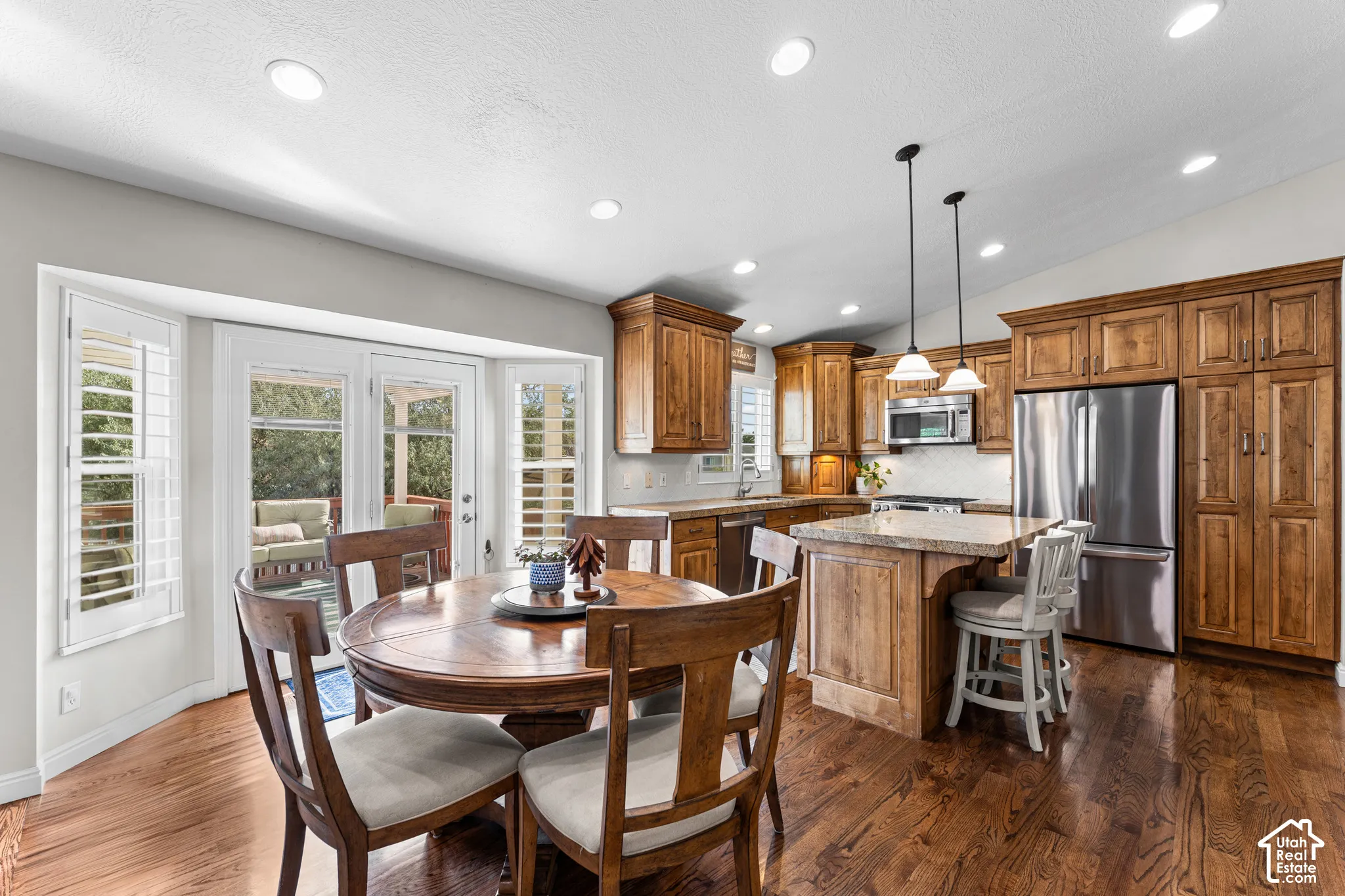 Wood-finish flooring, recessed lighting, and kitchen island with counter seating