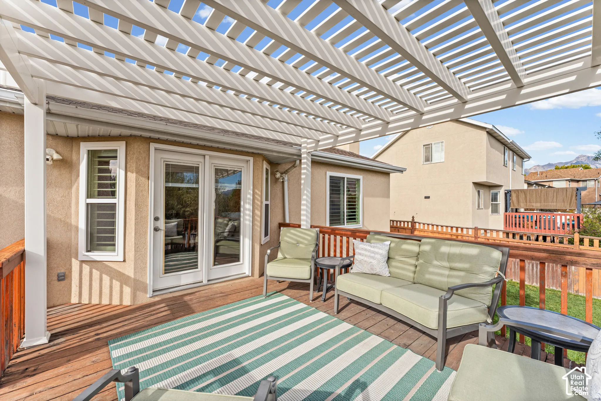 Wood-finish deck with a white slatted pergola