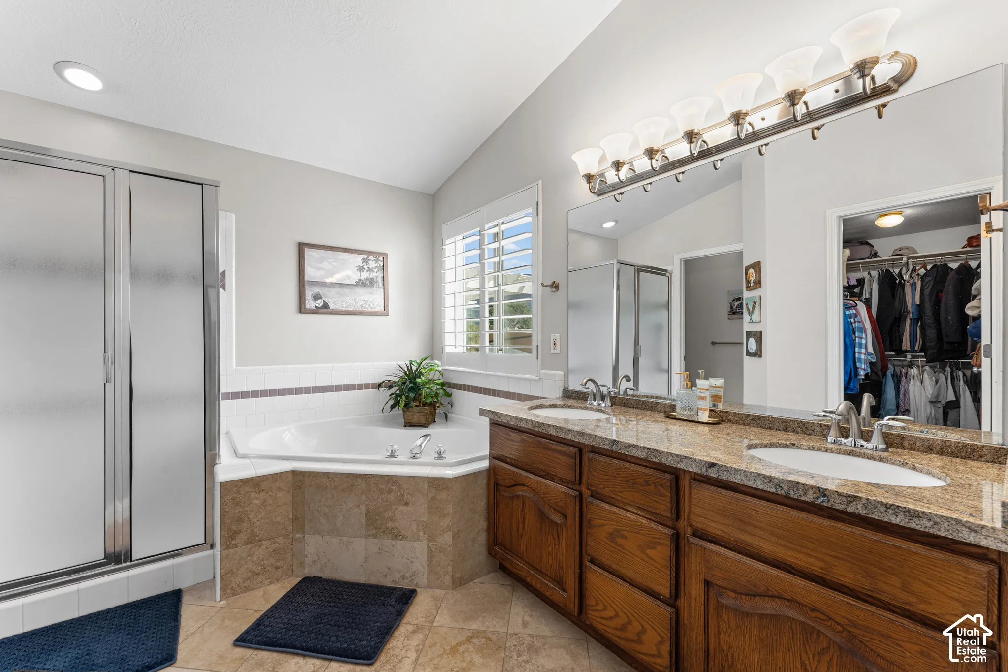 Dual vanity with granite-style countertop, integrated sinks, and wood cabinetry