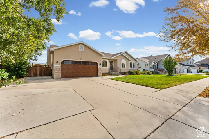 Stucco exterior with stone accents and a wood-finish garage door