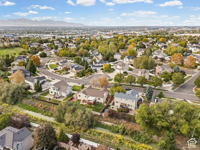 Residential neighborhood with mature trees, curved streets, and mountain backdrop