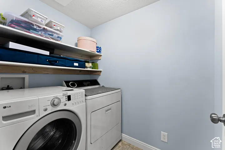Laundry space featuring a front-loading washing machine, dryer, and built-in shelving