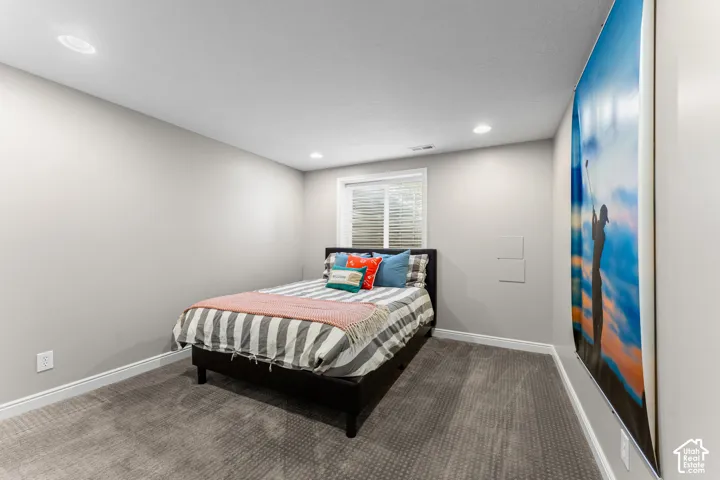 Recessed ceiling lighting, window with blinds, light gray wall paint, and gray carpeted flooring