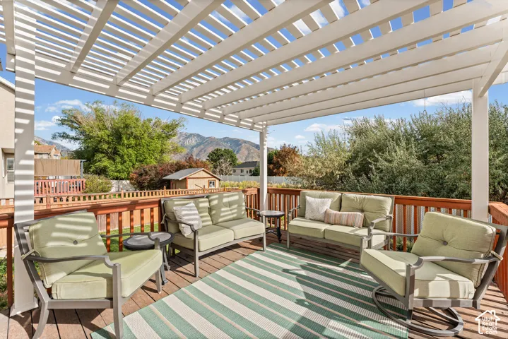 Expansive wood-finish deck with a white slatted pergola