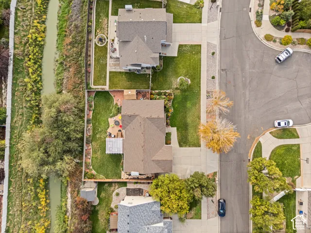Expansive backyard with a manicured lawn, built-in patio, and mature trees
