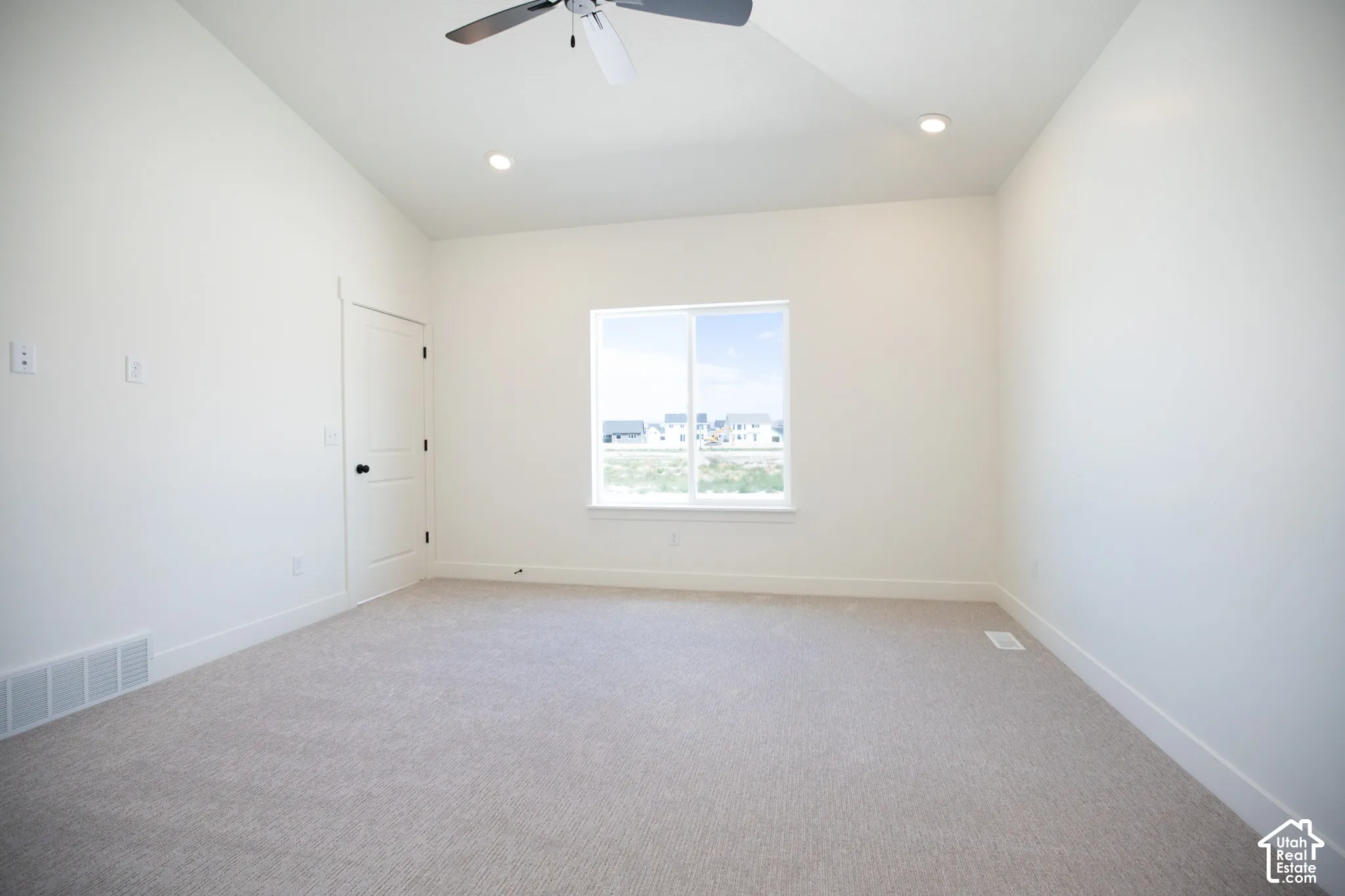 Primary bedroom with vaulted ceiling, ceiling fan and large walk-in closet as part of primary suite.