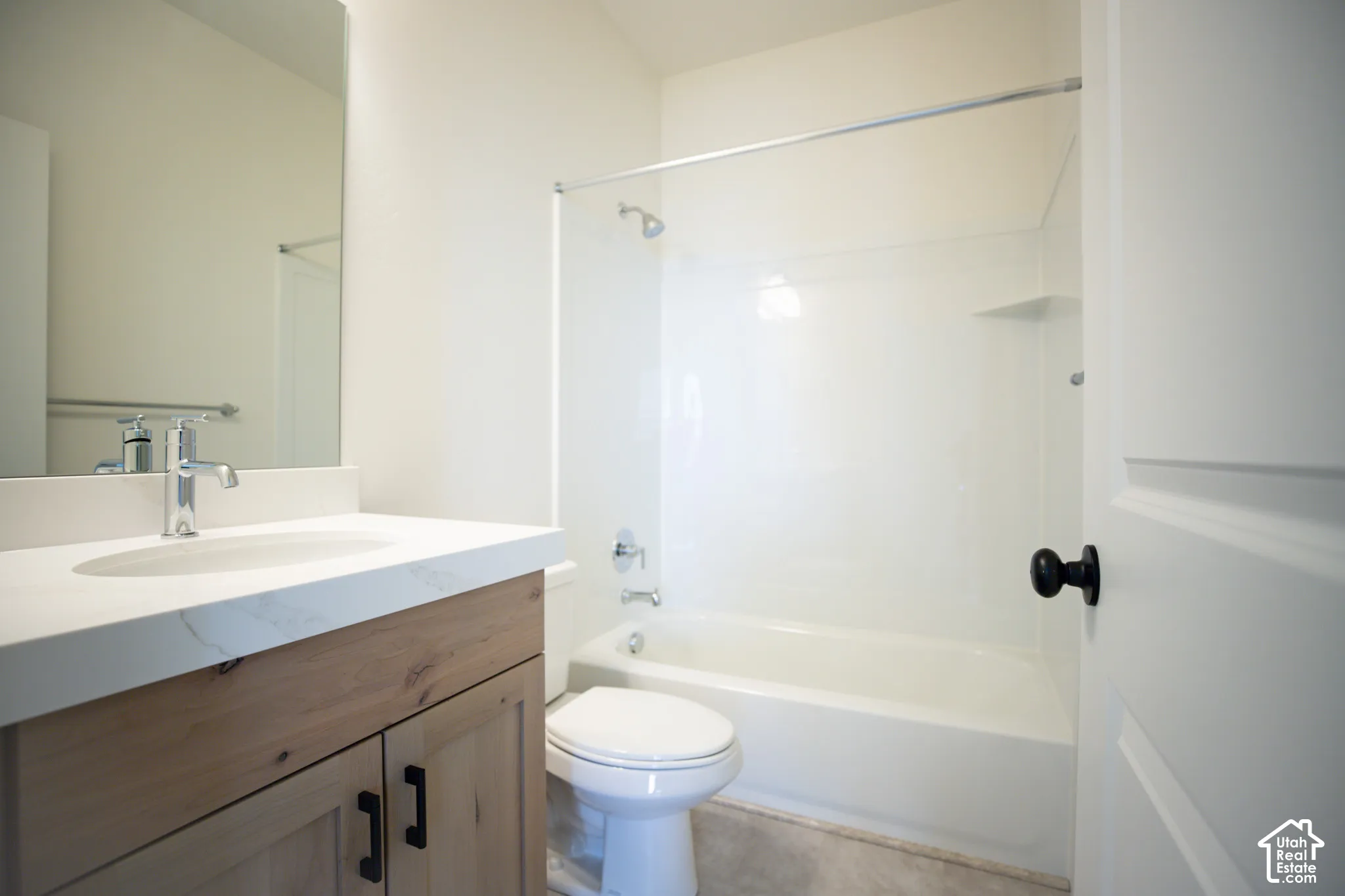 Full secondary bath with stained wood cabinets and quartz slab countetops.