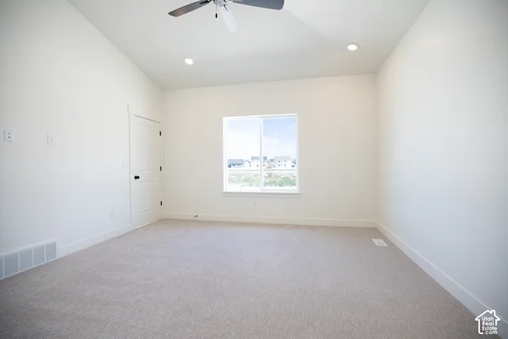 Primary bedroom with vaulted ceiling, ceiling fan and large walk-in closet as part of primary suite.