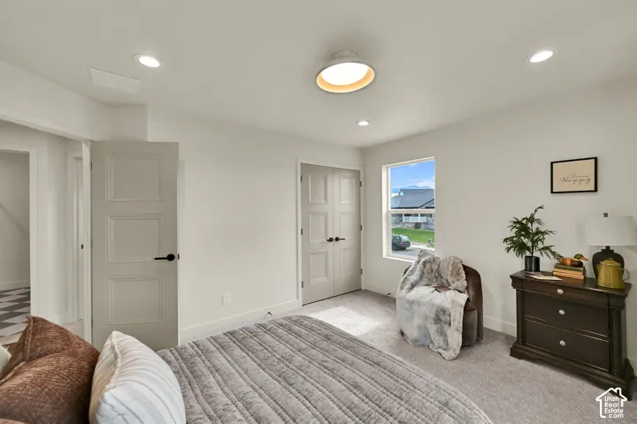 Recessed lighting, contemporary flush-mount ceiling fixture, multiple paneled doors, and a window providing natural light