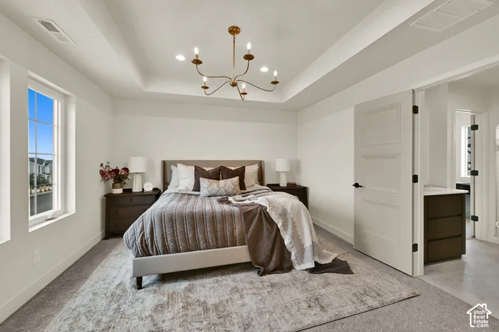 Tray ceiling with recessed lighting and a decorative chandelier